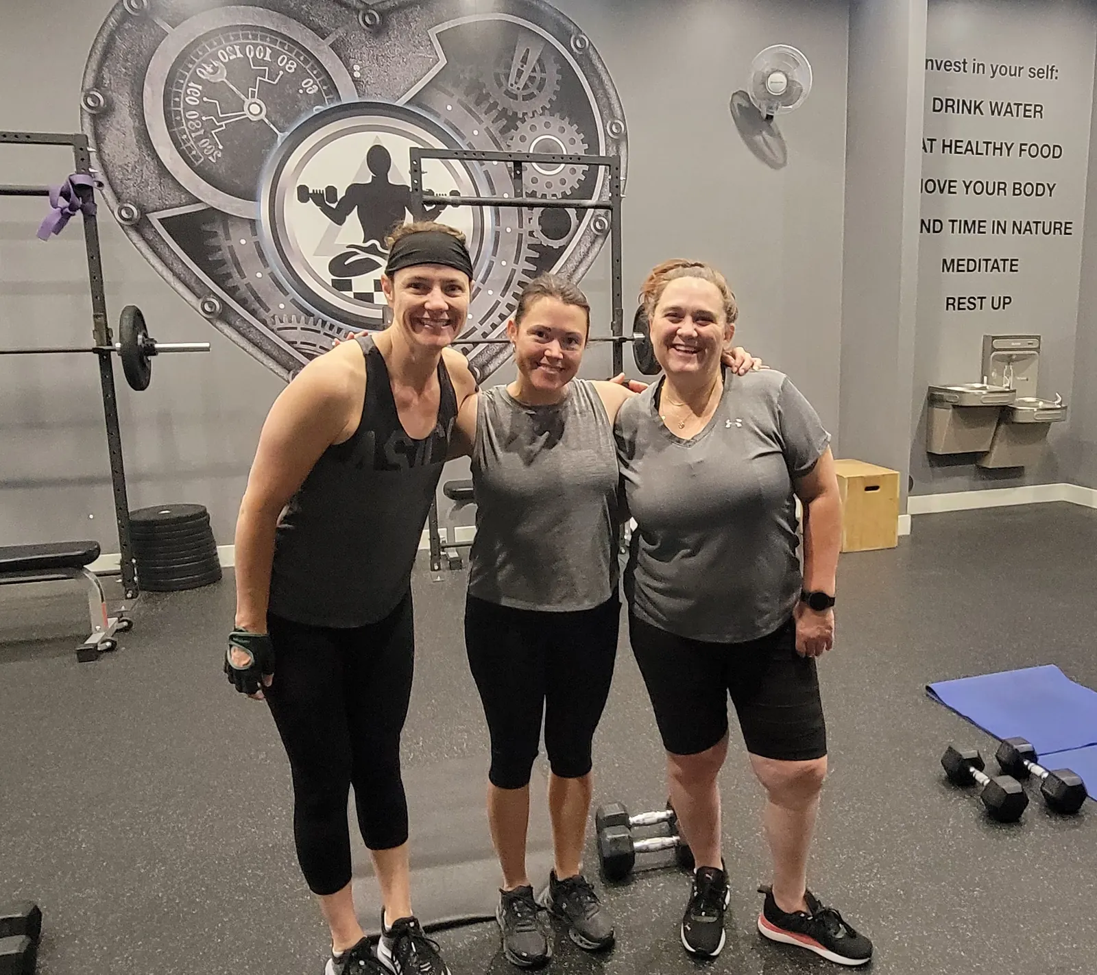 Three Fit Factory members smiling together after a workout